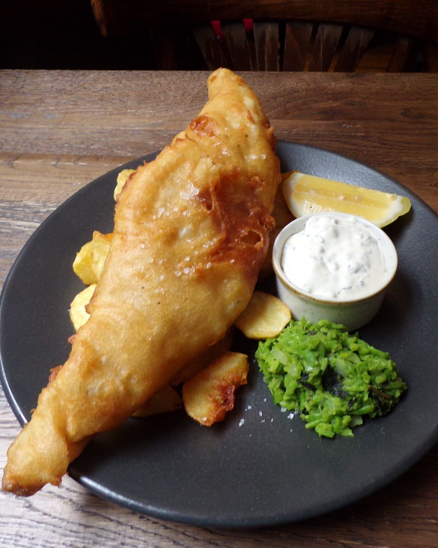 Battered fish pub main with potatoes and mushy peas