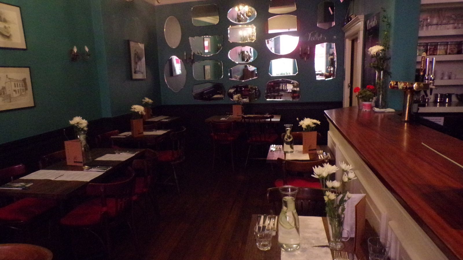 The dark-green dining room and long bar inside Garrick's Head